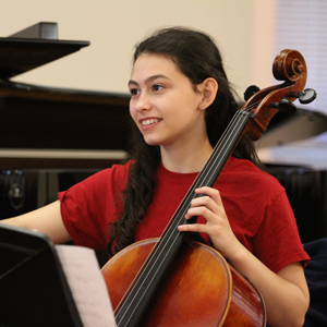 A photo of a female teen playing the cello.