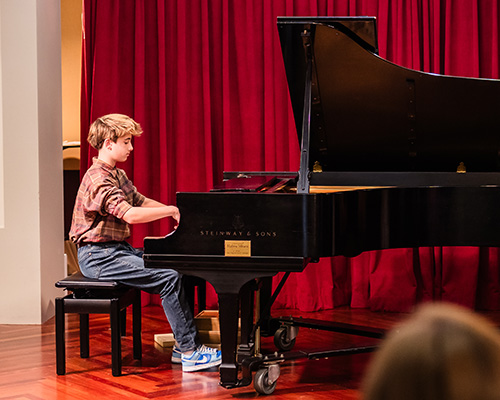 Student playing piano in a recital.