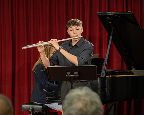 Student playing flute in a recital.
