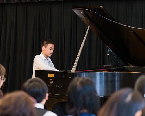 Student playing piano in a recital.