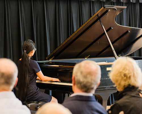 Student playing piano in a recital.