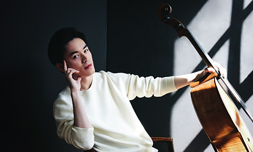 Benett Tsai seated with a cello.