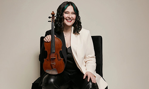 Image of Ariel Horowitz seated holding a violin.