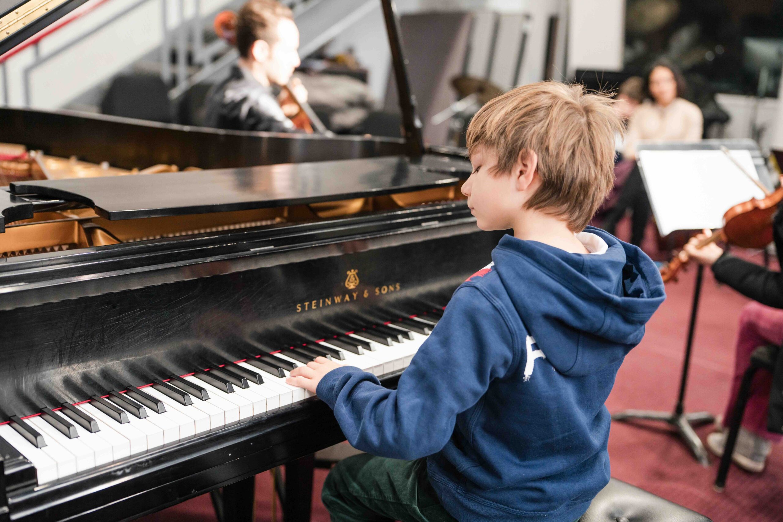 A Suzuki piano student playing in a workshop.