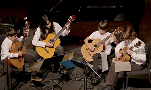 A guitar ensemble performing a concert.