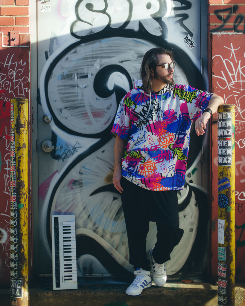 Jose Luiz Martins standing in front of a door with graffiti.