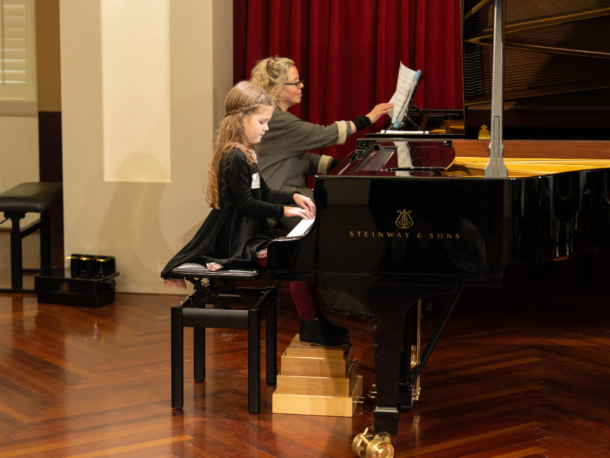 Young female pianist performing with an accompanist.