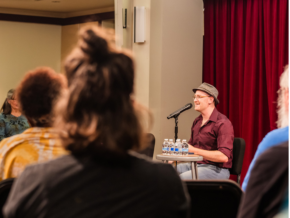 Micah Hendler leading a group of singers.