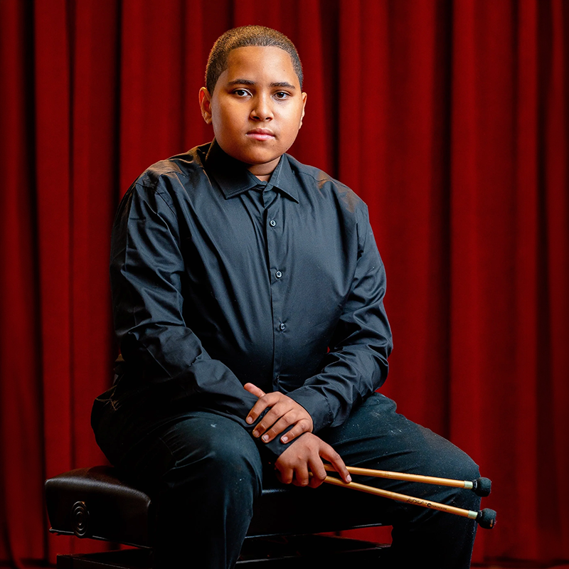 Image of Collyn Wilcher seated holding percussion mallets.