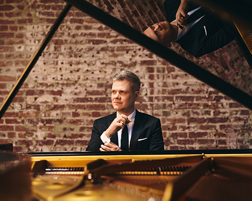 Greg Anderson sitting at a piano.